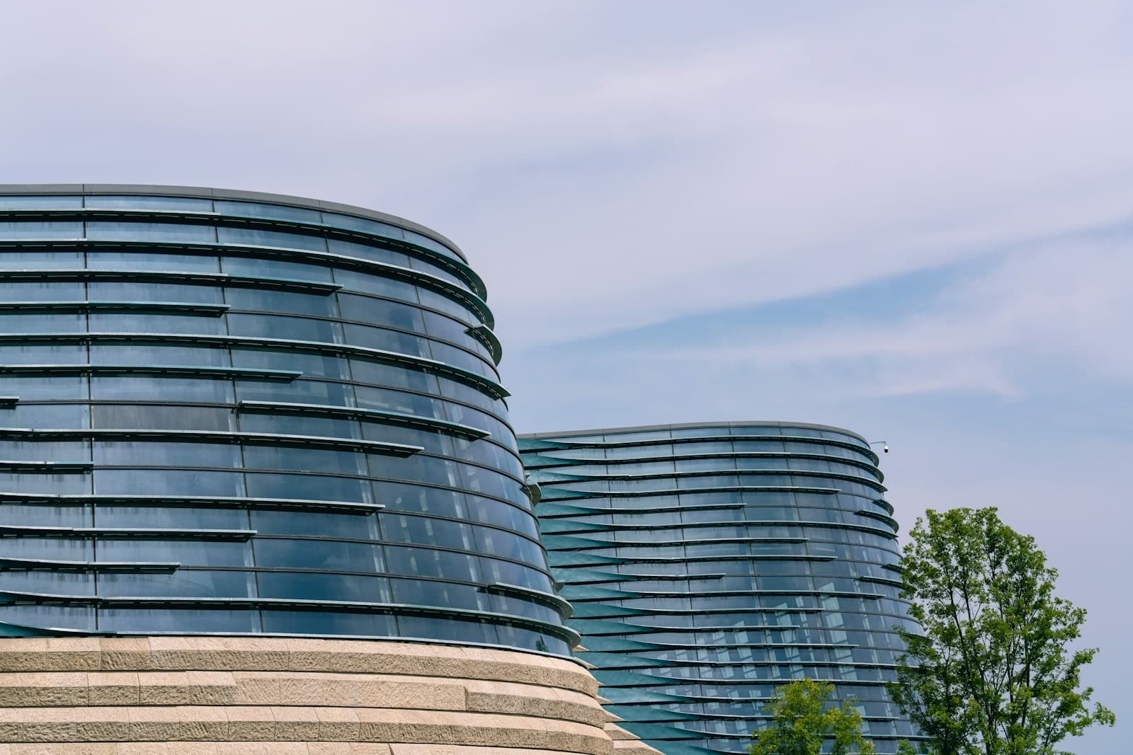 Curved glass office buildings against a pale sky